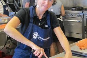 The author filets a salmon in the kitchen of Johnson & Wales.
