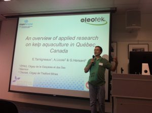 a man standing in front of a projection screen with a microphone