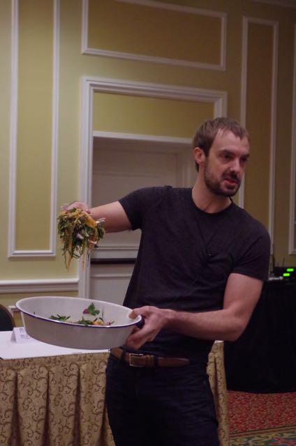 Barton Seaver holds a handful of seaweed over a bowl