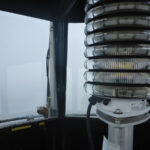 Close up of lighthouse lens, from inside tower. Foggy background