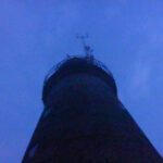 Light house tower photographed from below, night sky.