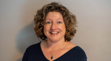 Woman with a black shirt looking at the camera and smiling