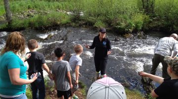a group of people in front of a river