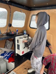 a young person at the wheel of the boat