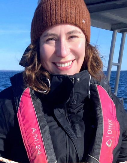 headshot of Cara Blaine on a boat wearing a hat and life vest