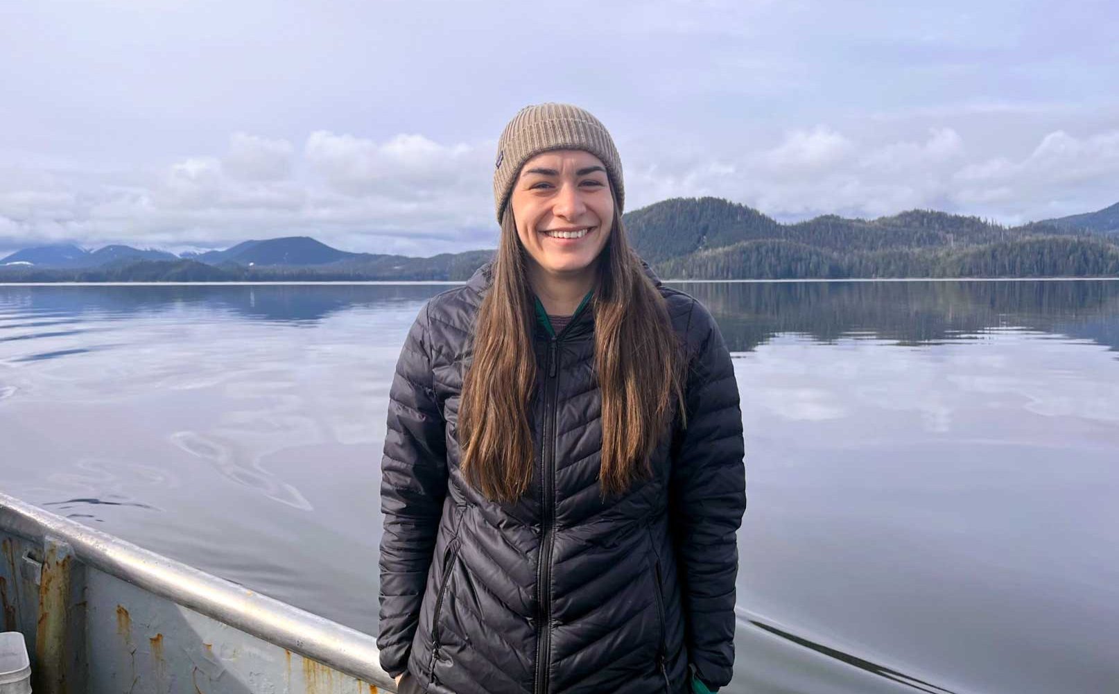 Krissa Davis smiles for the camera with a body of water in the background.