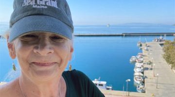 person in a Sea Grant hat with a coastal background