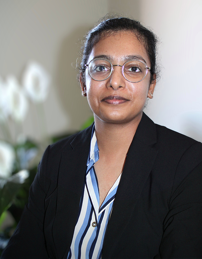 Harsha wearing a striped shirt and black blazer